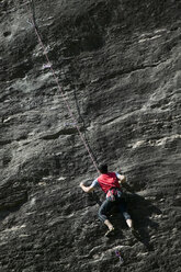 Rock climber climbing rock face - CUF03615