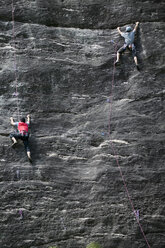 Rock climbers climbing rock face - CUF03616