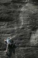 Rock climber climbing rock face - CUF03617