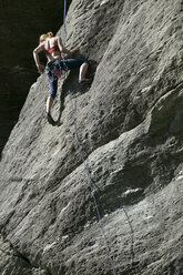 Rock climber climbing rock face - CUF03618