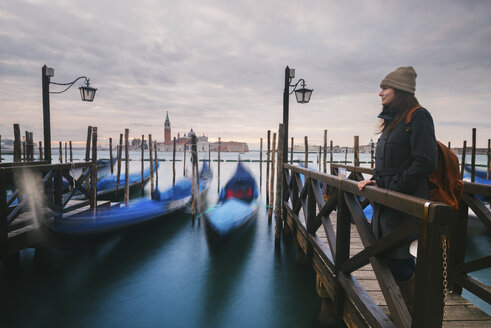 Frau auf dem Pier neben Gondeln im Canal Grande, im Hintergrund die Insel San Giorgio Maggiore, Venedig, Italien - CUF03836