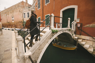 Frau überquert Brücke über Kanal, Venedig, Italien - CUF03841