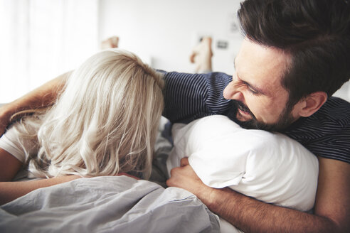 Pärchen auf dem Bett liegend, Mann kitzelt Frau - CUF03949