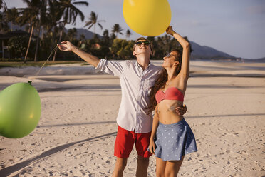 Junges Paar am Strand mit Blick auf Luftballons, Koh Samui, Thailand - CUF03995