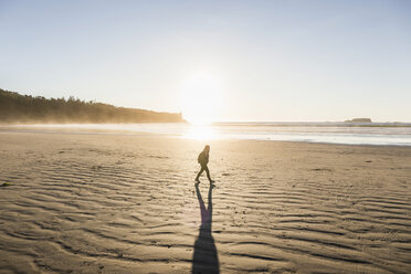 Woman strolling on Long Beach at sunrise, Pacific Rim National Park, Vancouver Island, British Columbia, Canada - CUF04098