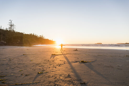 Mann tanzt am Long Beach bei Sonnenuntergang, Pacific Rim National Park, Vancouver Island, British Columbia, Kanada - CUF04105