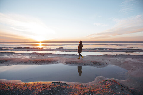 Frau genießt den Strand bei Sonnenuntergang, lizenzfreies Stockfoto