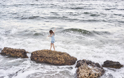 Frau genießt Spaziergang auf Felsen im Meer - CUF04126