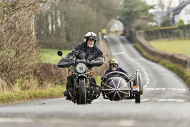 Three men wearing open face crash helmets and goggles riding cafe racer  motorcycles along rural road Stock Photo - Alamy