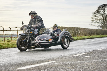 Three men wearing open face crash helmets and goggles riding cafe racer  motorcycles along rural road Stock Photo - Alamy