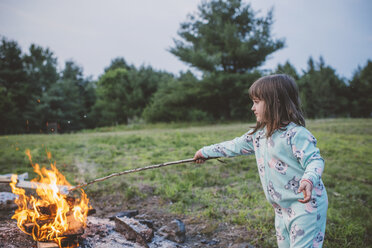 Young girl toasting marshmallow in fire - ISF00920