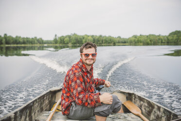 Portrait of young man in boat on lake - ISF00921