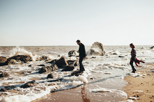 Mid adult couple standing on rocks at water's edge on beach, Odessa Oblast, Ukraine - ISF00930