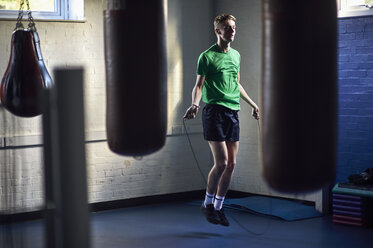 Junger männlicher Boxer, der im Fitnessstudio hüpft - CUF04290