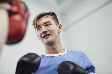 Junger männlicher Boxer, der mit dem Boxhandschuh boxt - CUF04309