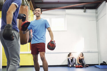 Male boxers training, in boxing gloves and punch mitts - CUF04313