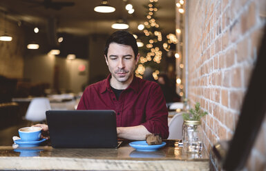 Mann arbeitet am Laptop in einem Café - CUF04326