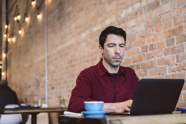 Mann arbeitet am Laptop in einem Café - CUF04327