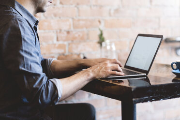 Mann arbeitet am Laptop in einem Café - CUF04335