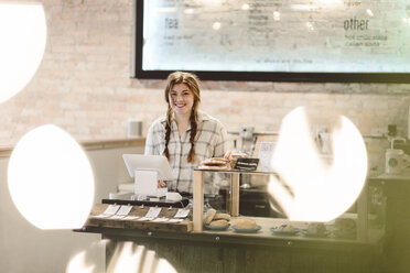 Kassiererin hinter der Kasse eines Cafés - CUF04348