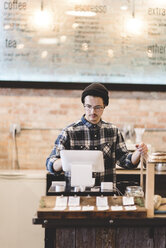 Cashier using cash register in cafe - CUF04358