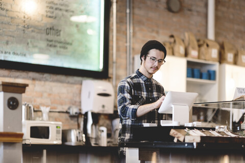 Kassiererin mit Registrierkasse in einem Cafe, lizenzfreies Stockfoto