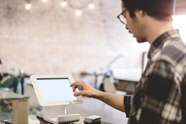 Cashier using cash register in cafe - CUF04361