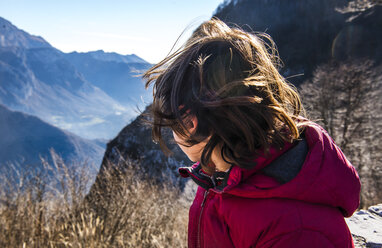 Blick über die Schulter eines Jungen auf eine Berglandschaft, Italien - CUF04392