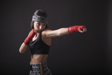 Portrait of young woman in fighting stance - CUF04416