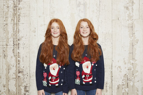 Portrait of twin sisters wearing Christmas jumpers - CUF04423