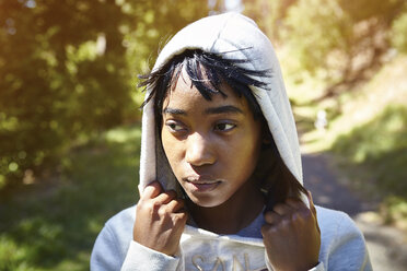 Young woman in rural setting, wearing hooded sweatshirt - CUF04442