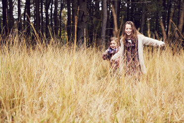 Two young girls running through meadow, hand in hand - CUF04461