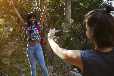 Zwei Freunde beim Wandern, junge Frau fotografiert ihren Freund mit dem Smartphone, Kapstadt, Südafrika - CUF04468