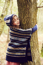 Junges Mädchen, das einen Baum umarmt - CUF04478