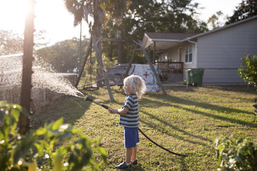 Boy spraying water from hosepipe - ISF00946