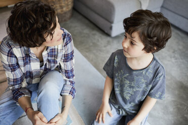 Mother and son at home, sitting on floor, talking - ISF01049