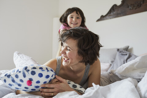 Mother and daughter playing in bedroom, laughing stock photo