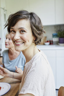 Portrait of mid adult woman at dinner table, smiling - ISF01082