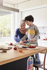 Großmutter und Enkel, die gemeinsam Pizza backen - ISF01102