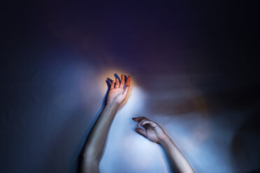 Woman's arms and hands raised, cropped low key studio shot - ISF01130