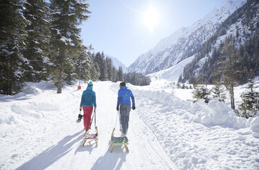 Paar mit Schlitten in schneebedeckter Landschaft - CVF00472