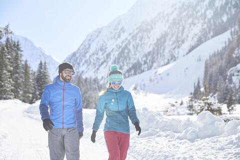 Paar geht in verschneiter Landschaft spazieren, lizenzfreies Stockfoto