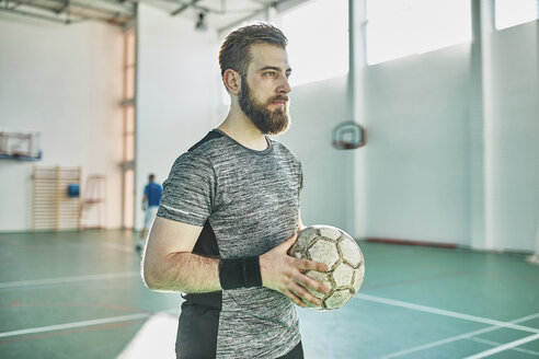 Porträt eines Hallenfußballspielers, der den Ball hält - ZEDF01418