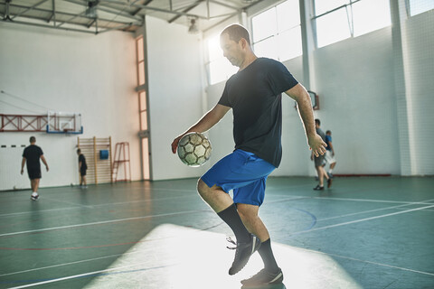 Hallenfußballspieler balanciert den Ball, lizenzfreies Stockfoto