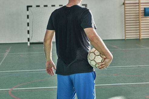 Rear view of indoor soccer player holding the ball - ZEDF01425