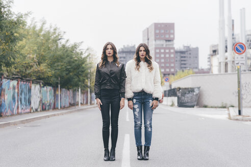 Portrait of twin sisters, in urban area, standing side by side - CUF04511