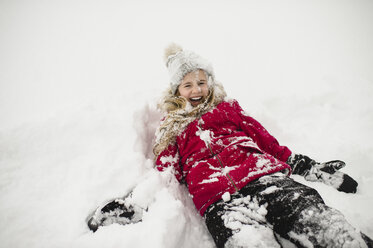 Lächelndes Mädchen auf dem Rücken liegend und mit Schnee bedeckt - CUF04535