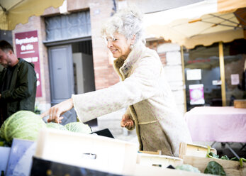 Ältere Frau kauft Gemüse auf einem lokalen französischen Markt - CUF04595