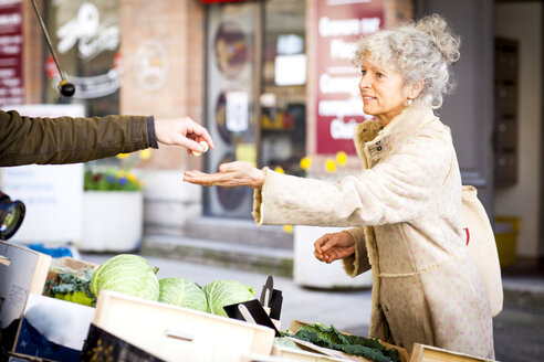 Ältere Frau kauft Gemüse auf einem lokalen französischen Markt - CUF04604