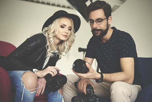 Fotografen betrachten die Kameraausrüstung im Fotostudio - CUF04705